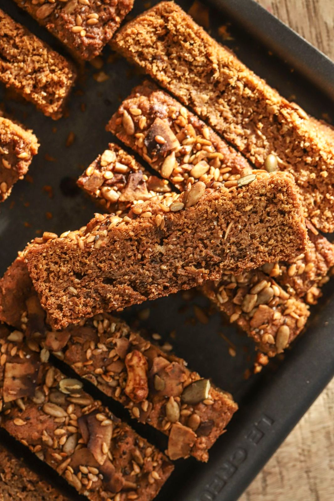 Homemade golden rusks with seeds and nuts on a baking tray.